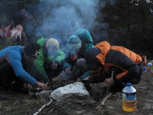 Group effort to make fire in the wet